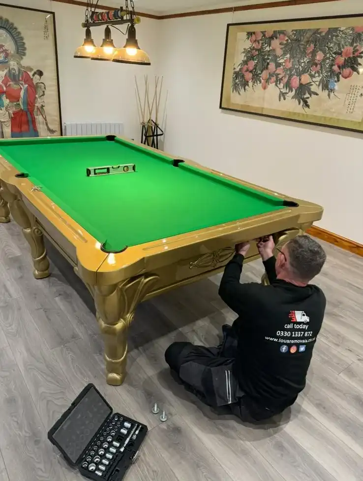 man reassembling a snooker table