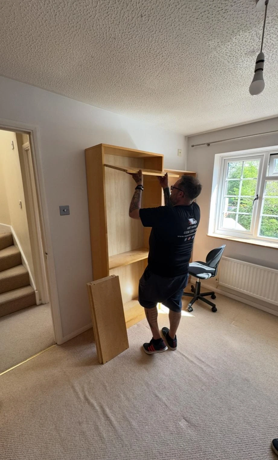 Man installing a bookcase.