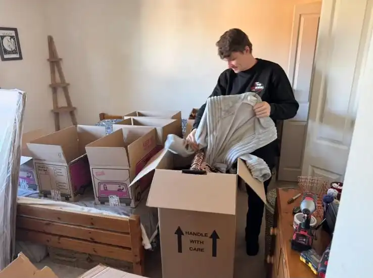 Man packing boxes with paper.
