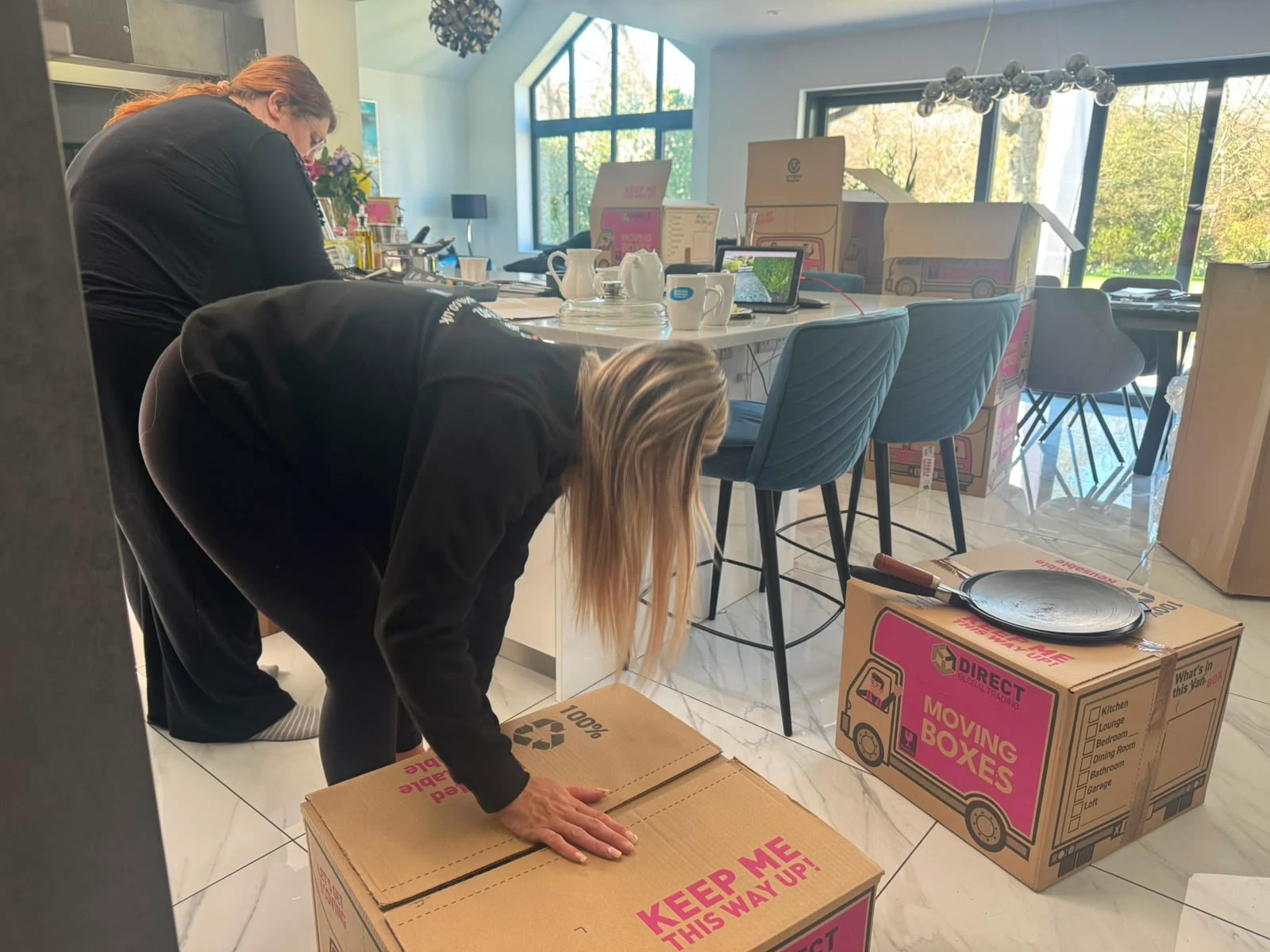 Girls packing boxes in the kitchen.