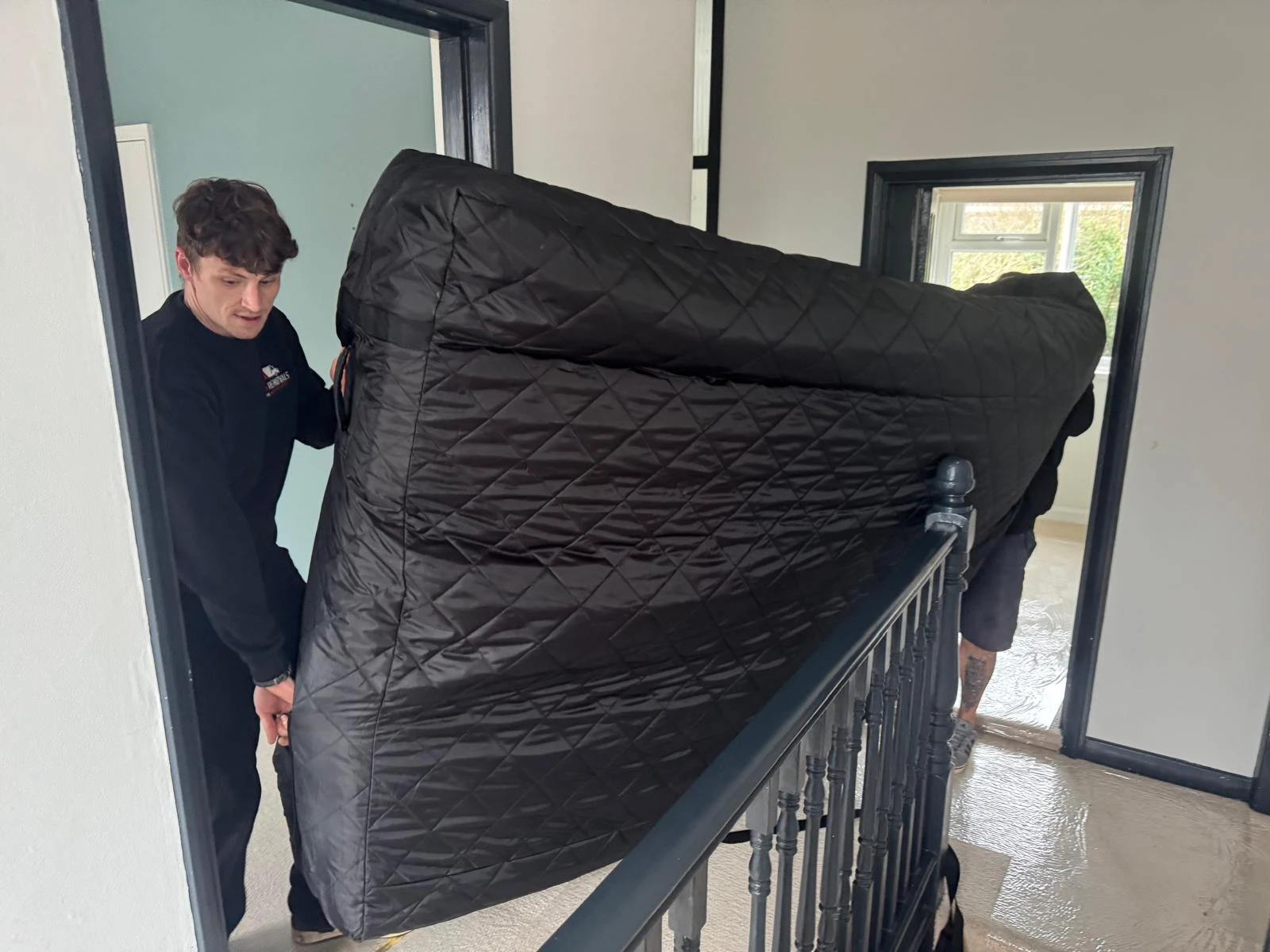 Men moving a double bed.